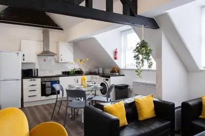 a kitchen and living room with a couch and a table at The residency appartment's in Litherland