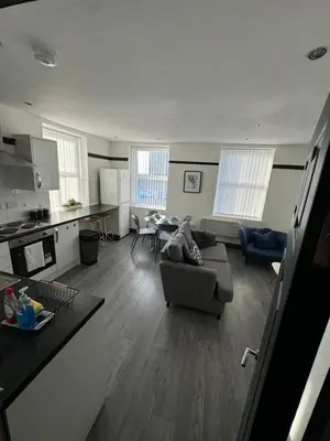 a large living room with a couch and a kitchen at The residency appartment's in Litherland