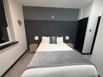 a bedroom with a large bed with two night stands at Woodhouse Hotel Blackpool Promenade in Blackpool