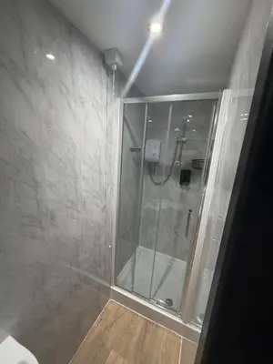 a shower with a glass door in a bathroom at Woodhouse Hotel Blackpool Promenade in Blackpool