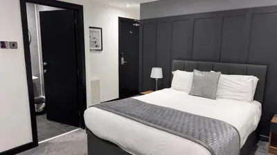 a bedroom with a large bed with a black headboard at Woodhouse Hotel Blackpool Promenade in Blackpool