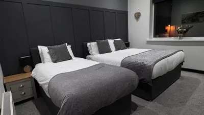 a bedroom with two beds and a window at Woodhouse Hotel Blackpool Promenade in Blackpool