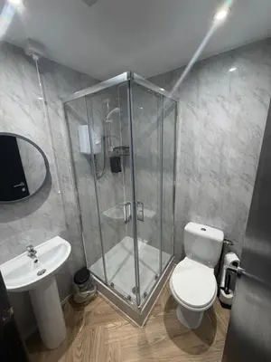a bathroom with a shower and a toilet and a sink at Woodhouse Hotel Blackpool Promenade in Blackpool