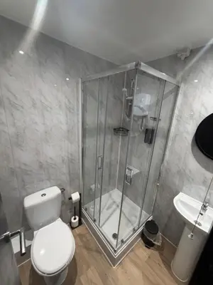 a bathroom with a shower and a toilet and a sink at Woodhouse Hotel Blackpool Promenade in Blackpool