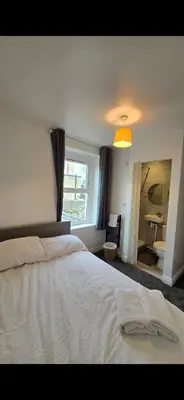 a bedroom with a white bed and a bathroom at Cozy Stays Lancaster in Lancaster