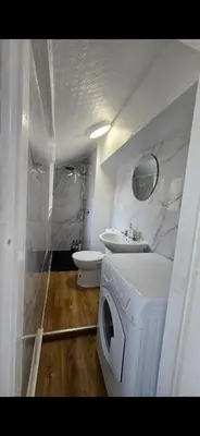 a bathroom with a washing machine and a sink at Cozy Stays Lancaster in Lancaster