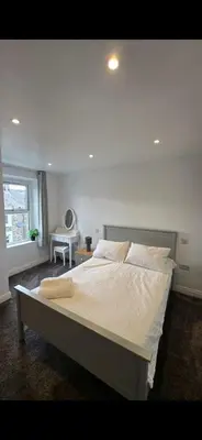 a large bed in a bedroom with a window at Cozy Stays Lancaster in Lancaster
