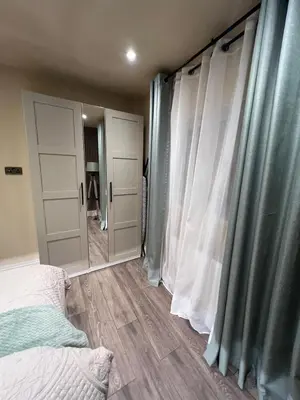 a bedroom with a bed and a large mirror at 2 bedroom self catering detached outhouse with garden area in Preston