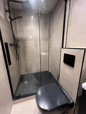 a shower with a black toilet in a bathroom at 2 bedroom self catering detached outhouse with garden area in Preston