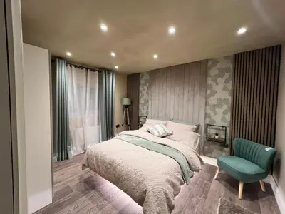 a bedroom with a bed and a green chair at 2 bedroom self catering detached outhouse with garden area in Preston