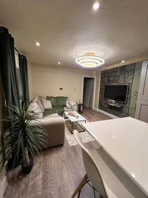 a living room with a couch and a tv at 2 bedroom self catering detached outhouse with garden area in Preston