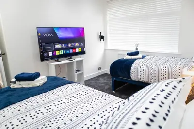 a bedroom with two beds and a flat screen tv at Stylish Preston Home 3 Beds Sleeps 6 in Preston