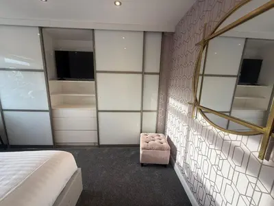 a bedroom with a bed and a mirror and a chair at Dalton House - Private Parking in Blackpool