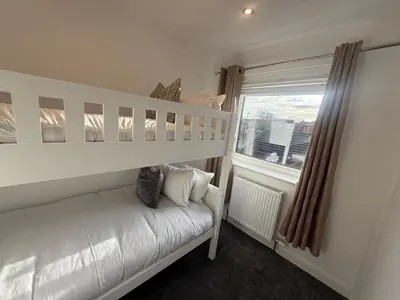 a bedroom with a white bunk bed and a window at Dalton House - Private Parking in Blackpool