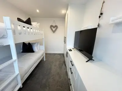 a bedroom with bunk beds and a flat screen tv at Dalton House - Private Parking in Blackpool