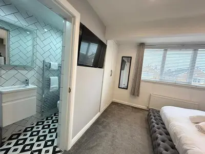 a bathroom with a shower and a bed and a sink at Dalton House - Private Parking in Blackpool