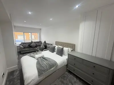 a bedroom with a large bed and a couch at Dalton House - Private Parking in Blackpool