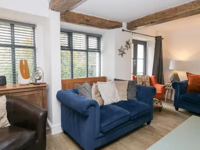 a living room with a blue couch and chairs at No 2 The Flags in Grange Over Sands