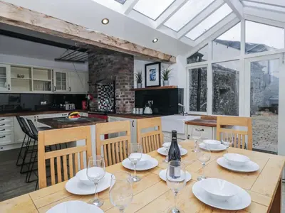a dining room with a table with wine glasses on it at No 2 The Flags in Grange Over Sands