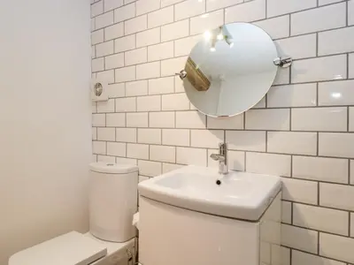 a bathroom with a toilet and a sink and a mirror at No 2 The Flags in Grange Over Sands