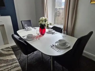 a white table with chairs and a vase of flowers at Peaceful Home in Hermitage Street Rishton in Rishton