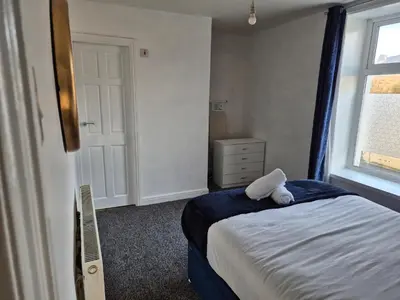 a bedroom with a bed with a teddy bear on it at Peaceful Home in Hermitage Street Rishton in Rishton