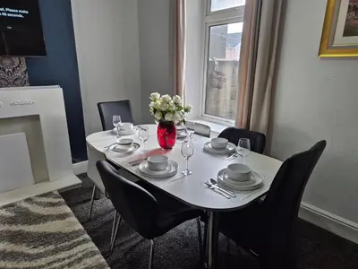 a dining room table with a vase of flowers on it at Peaceful Home in Hermitage Street Rishton in Rishton