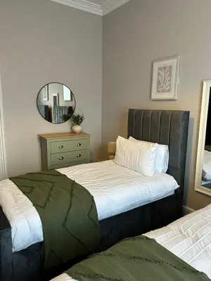 a bedroom with two beds and a mirror at A Comfy Stay Close to City-Centre in Preston
