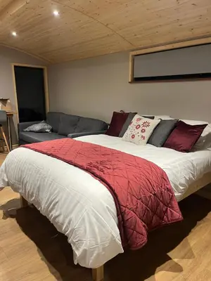 a bedroom with a large bed and a couch at Mill House Farm Pods- Kingfisher in Pilling