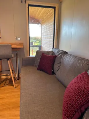 a couch with two pillows on it in a living room at Mill House Farm Pods- Kingfisher in Pilling