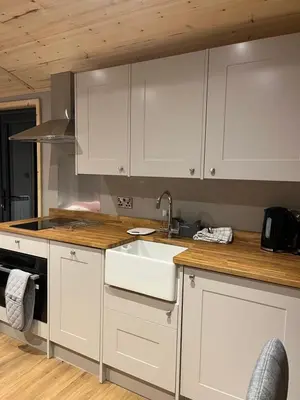 a kitchen with white cabinets and a sink at Mill House Farm Pods- Kingfisher in Pilling