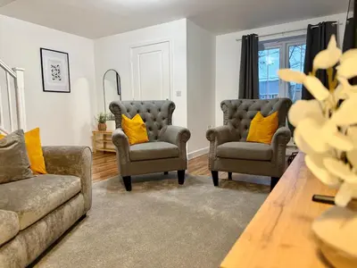 a living room with two couches and yellow pillows at 4 Bed - Parking - Fast WiFi - Desk - M6 M61 links - Pets in Leyland
