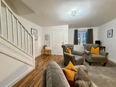 a living room with a couch and two chairs at 4 Bed - Parking - Fast WiFi - Desk - M6 M61 links - Pets in Leyland