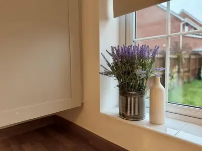 a window sill with a vase and flowers on it at 4 Bed - Parking - Fast WiFi - Desk - M6 M61 links - Pets in Leyland