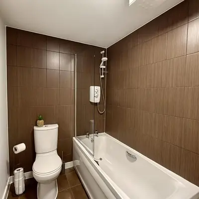 a bathroom with a toilet and a bath tub at 4 Bed - Parking - Fast WiFi - Desk - M6 M61 links - Pets in Leyland