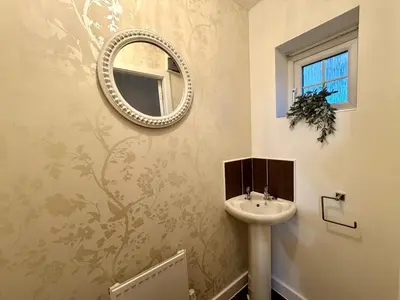 a bathroom with a sink and a mirror on the wall at 4 Bed - Parking - Fast WiFi - Desk - M6 M61 links - Pets in Leyland