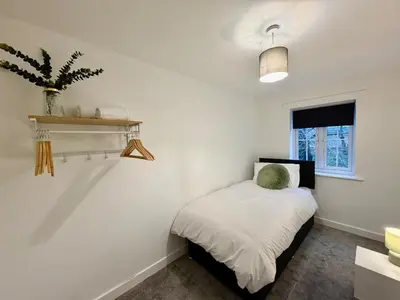 a small bedroom with a bed and a window at 4 Bed - Parking - Fast WiFi - Desk - M6 M61 links - Pets in Leyland