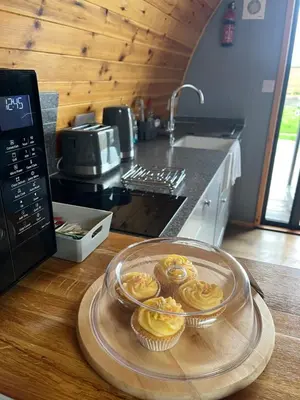 a glass plate with cupcakes on a counter in a kitchen at Mill House Farm Pods - Mallard View in Pilling