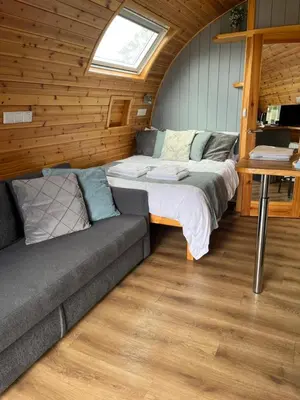 a bedroom with a bed and a couch in a room at Mill House Farm Pods - Mallard View in Pilling
