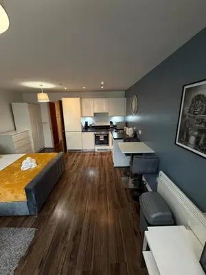 a bedroom with a bed and a kitchen with a table at Stunning City View Studio Apartment by StaySavvy Accommodation in Liverpool