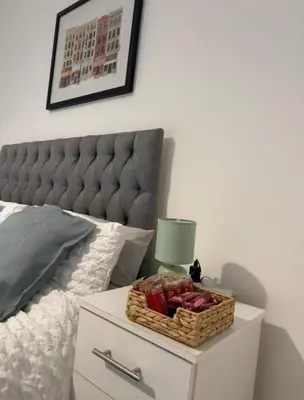 a basket of fruit on a nightstand next to a bed at Cosy Double and Triple Bedrooms 5 minutes from Anfield Stadium in Liverpool