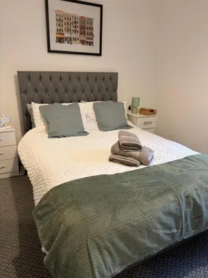 a bedroom with a large bed with two towels on it at Cosy Double and Triple Bedrooms 5 minutes from Anfield Stadium in Liverpool