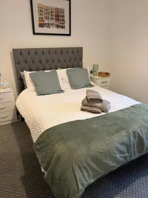 a bedroom with a large bed with two pillows at Cosy Double and Triple Bedrooms 5 minutes from Anfield Stadium in Liverpool