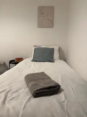 a white bed with a blanket on it with a pillow at Cosy Double and Triple Bedrooms 5 minutes from Anfield Stadium in Liverpool