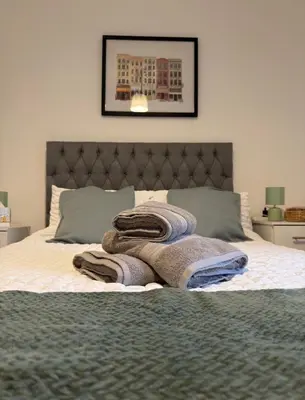 a bedroom with a bed with towels on it at Cosy Double and Triple Bedrooms 5 minutes from Anfield Stadium in Liverpool