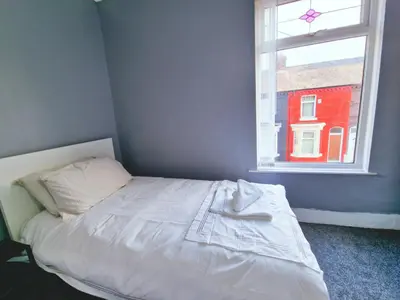 a bedroom with a white bed with a window at Stylish Modern Home comfy setting by Everton Park in Liverpool