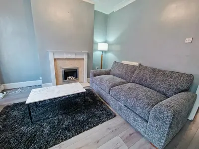 a living room with a couch and a fireplace at Stylish Modern Home comfy setting by Everton Park in Liverpool