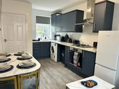 a kitchen with blue cabinets and a white refrigerator at Contractors, Discounts, Free Parking, 4 BR, Sleep7 in Bidston