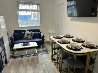 a living room with a table and a blue couch at Contractors, Discounts, Free Parking, 4 BR, Sleep7 in Bidston