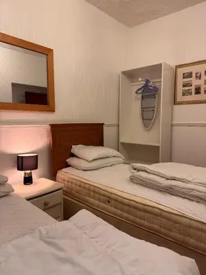 a room with two beds and a mirror and a mirror at No 34 Vance Road in Blackpool